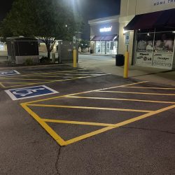 A parking lot featuring clearly marked yellow lines on the asphalt surface, indicating designated parking spaces.